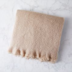 a beige blanket laying on top of a white counter