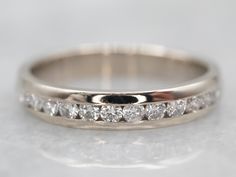 a close up view of a wedding ring with diamonds