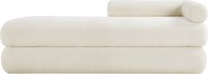 the back end of a white couch with two pillows on it and an arm rest