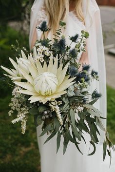 a bride holding a bouquet of flowers in her hands