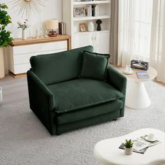 a living room with a green chair and white coffee table in front of a window