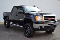 a black truck parked in front of a white building