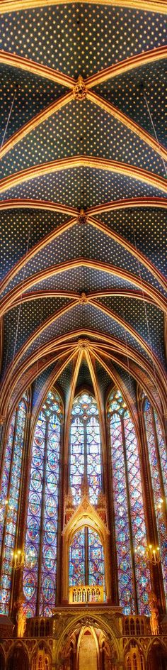 the inside of a large cathedral with stained glass windows and vaulted ceiling, all lit up