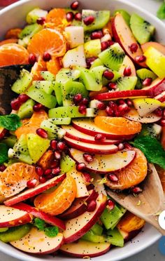 a white bowl filled with sliced fruit and pomegranates