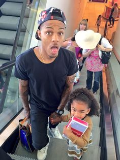 a man and his daughter on an escalator