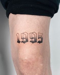 a man with a tattoo on his leg has the number 955 written in black ink