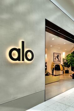 an alo sign on the side of a building with potted plants in it