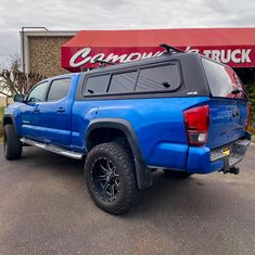 a blue truck parked in front of a store