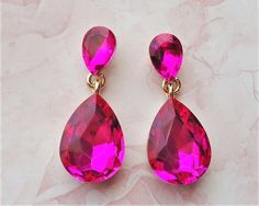 Elegant, opulent, and shimmery  This brilliant classic earrings features hot pink Swarovski crystals. Crystals are set on a secure prong settings, made of brass and plated in 18 karat gold. These earrings have surgical steel posts and measure 1.25" in length. Earrings are light weight and sway gracefully as you move about your day. These stunning dangle earrings are unique, feminine and eye-catching, Perfect for a bride that wants to make a statement or anyone to wear to a special occasion! Pink Teardrop Bridal Earrings For Party, Pink Drop Crystal Earrings For Party, Pink Jewelry For Valentine's Evening, Pink Drop Earrings For Party, Pink Drop Crystal Earrings For Wedding, Pink Sparkling Stones Crystal Earrings For Wedding, Pink Crystal Earrings With Sparkling Stones For Wedding, Pink Crystal Bridal Earrings For Party, Pink Crystal Earrings For Formal Occasions