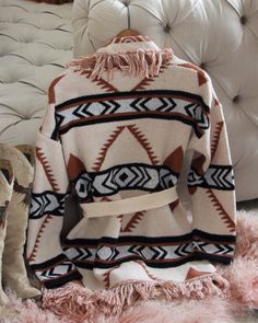 A stunning knit blanket sweater that is perfectly cozy for the season. Open front & soft fringe fold over collar. Color: Cream, camel & black Poly Hand wash cold Model is a size 8 wearing a medium. Small Medium Large Bust 50 52 53 Waist 49 51 52 Hips 51 53 54 Length 31 31 31 Bust, waist, and hip measurements are a total circumference. Length is measured from the top of the shirt to the hem. Measurements are an estimate. Knit Outerwear With Fringe For Fall, Knit Fringe Outerwear For Fall, Long Sleeve Knit Outerwear With Fringe, Knit Long Sleeve Outerwear With Fringe, Fringe Knit Outerwear With Long Sleeves, Fall Fringe Knit Cardigan, Camel Long Sleeve Sweater For Fall, Long Sleeve Camel Sweater For Fall, Cozy Long Sleeve Outerwear With Fringe