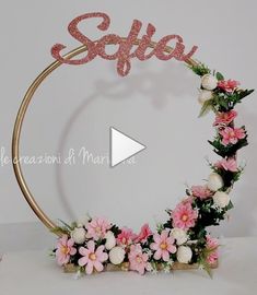 a pink and white flower wreath with the word schle on it's side