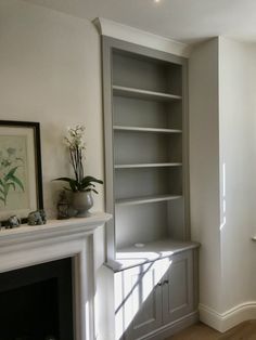 a living room with a fireplace and built in shelves