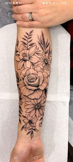 a woman's foot with flowers and leaves tattooed on the side of her leg