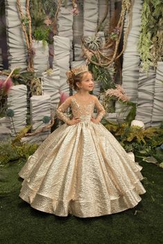 Elevate your little princess's special occasion ensemble with The Yana Girls Pageant Gown in Taffeta & Brocade. This stunning gown features a sheer bodice with long sleeves, adorned with a breathtaking design of floral crystal beaded lace embroidery. The full pageant wedding flower girls gown is truly spectacular, with a gorgeous brocade skirt that boasts a hint of a train for added drama. A beautiful bow that creates the perfect finishing touch on this magnificent ball gown. Get ready to turn h Gold Flower Girl Dress, Gold Flower Girl, Girls Gold Dress, Girls Pageant Gowns, Pink Flower Girl Dresses, Princess Flower Girl Dresses, Kids Gown, Bow Belt, Flower Girl Dress Lace