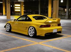 a yellow sports car parked in a parking garage