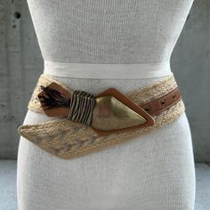 90s jute belt, chunky arrowhead buckle with feathers, vintage summer accessories, tribal fashion statement belt, boho hippie, tribal glam  Transport yourself to the free-spirited vibes of the 90s with our Vintage Jute Belt, a distinctive accessory that effortlessly captures the essence of summer style. This tribal fashion statement belt is a fusion of boho hippie allure and tribal glam, a wearable masterpiece that invites you to embrace the artistry of vintage summer accessories. Crafted from jute, the wide band showcases intricate embroidery in neutral tones, creating a harmonious canvas that tells a story of ethnic elegance. The chunky arrowhead buckle takes center stage, a bold adornment that adds an element of tribal mystique to the belt. Adorned with feathers, it becomes a symbol of f Embroidered Belt For Summer Beach, Summer Beach Embroidered Belt, Adjustable Bohemian Fabric Belt, Bohemian Fabric Belt For Festivals, Bohemian Adjustable Belts For Summer, Bohemian Brown Belt For Festival, Bohemian Adjustable Belt For Festivals, Adjustable Bohemian Belt For Festivals, Bohemian Brown Fabric Belt