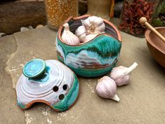 garlic and garlic bulbs are sitting on the ground next to a potted planter