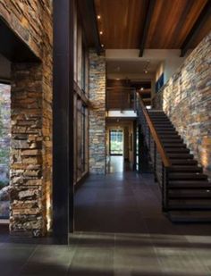 the interior of a house with stone walls and stairs leading up to an open floor plan