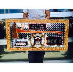 a man holding up a framed display with items on it's sides and the words csm - 2013