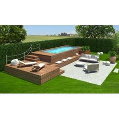 an outdoor swimming pool with lounge chairs around it in the middle of a grassy area