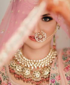 a woman wearing a pink veil and jewelry