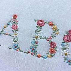 an embroidered name with flowers on it and the word aoa spelled out in large letters