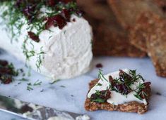 a piece of food that is sitting on a table next to some crackers and a knife