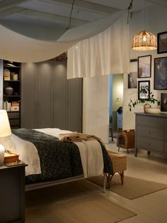 a bedroom with a bed, dressers and pictures on the wall