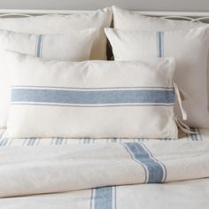 a bed with white and blue pillows on top of it