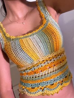 a close up of a person wearing a tank top with crochet on it