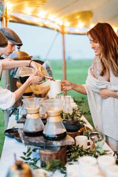 two women pouring coffee into cups at an outdoor event