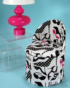 a white chair sitting next to a pink lamp on top of a blue tablecloth