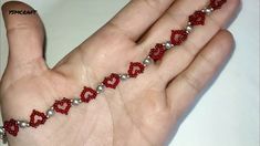 a person's hand with red and white beads on it