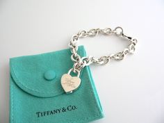 Offered for sale is a wonderful and rare Tiffany and Co. Sterling Silver Notes Heart Padlock bracelet.   The piece is made from substantial and bright Tiffany silver, and yet retains a very feminine feel to it.  Attached to its very substantial Tiffany Silver charm bracelet is a Heart padlock charm with "Tiffany & Co" written in beautiful script.  The Notes Heart padlock charm can be removed from the bracelet, and thus can be used as a pendant on a necklace or placed on another charm bracele Padlock Bracelet, Pandora Bracelet Charms Ideas, Tiffany And Co Bracelet, Tiffany And Co Jewelry, Heart Padlocks, Pandora Bracelet Charms, Gift Love, Silver Charm Bracelet, Tiffany And Co