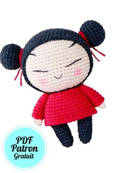 a crocheted doll with black hair wearing a red dress and holding her eyes closed