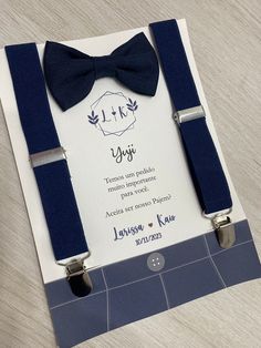 a blue bow tie and matching suspenders are on display in front of a card