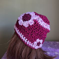 a woman's head wearing a crocheted hat with flowers