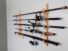 a wall mounted fishing rod holder with several rods and reels attached to the hooks