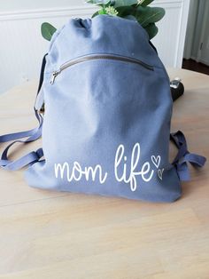 This mom life draw Sting Canvas Bag Is everything! It is Huge and perfect for fitting all your mama aka kids essentials Perfect for running out throwing snacks, wallet and diaper on the go instead of lugging that huge diaper bag around. 17 inches Long 14 1/4 inches wide 14.0 oz., 100% cotton Large main compartment Front zippered pocket with antique brass zipper Webbing straps Available in Black and Blue FOLLOW US ON SOCIAL MEDIA: Instagram: @righthereathome Facebook: @righthereathome Connect wit Cute Cotton Backpack For Everyday Use, Cute Everyday Cotton Backpack, Cute Everyday Standard Backpack, Large Capacity Backpack Bags For Gifts, Large Capacity Backpack Bags As Gifts, Large Capacity Backpack For Gifts, Large Capacity Backpack Bag For Gift, Cute Everyday Diaper Backpack, Everyday Backpack With Large Capacity Pouch