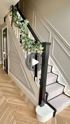 the stairs are decorated with flowers and greenery for an elegant entrance to this home