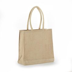 a beige bag on a white background with the handles down and one hand holding it