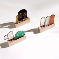 three pieces of wood with different shapes and colors on them, sitting side by side