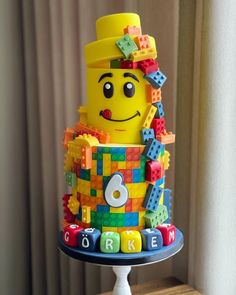 a yellow lego cake with the number six on it's side and an orange top hat