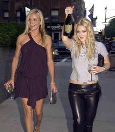 two women walking down the street holding wine bottles