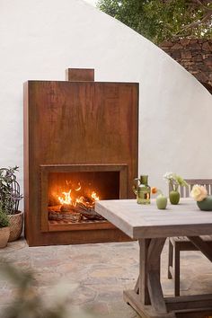 an outdoor fireplace in the middle of a patio