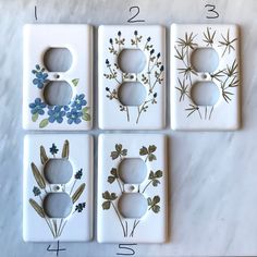 four light switch covers with flowers painted on them