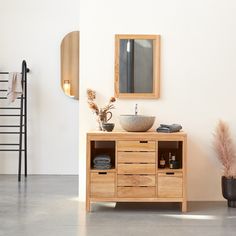 a bathroom with a sink, mirror and wooden cabinet in it's center area