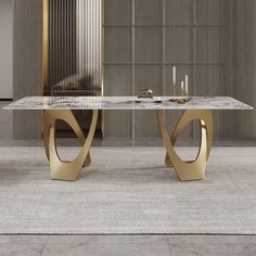 a marble and gold dining table with two candles on each side, in front of a wall