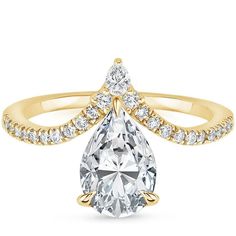 a yellow gold engagement ring with a pear shaped diamond in the center and side stones