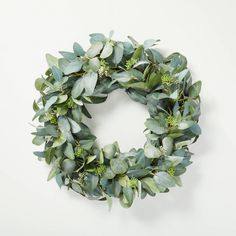 a wreath made out of green leaves and greenery